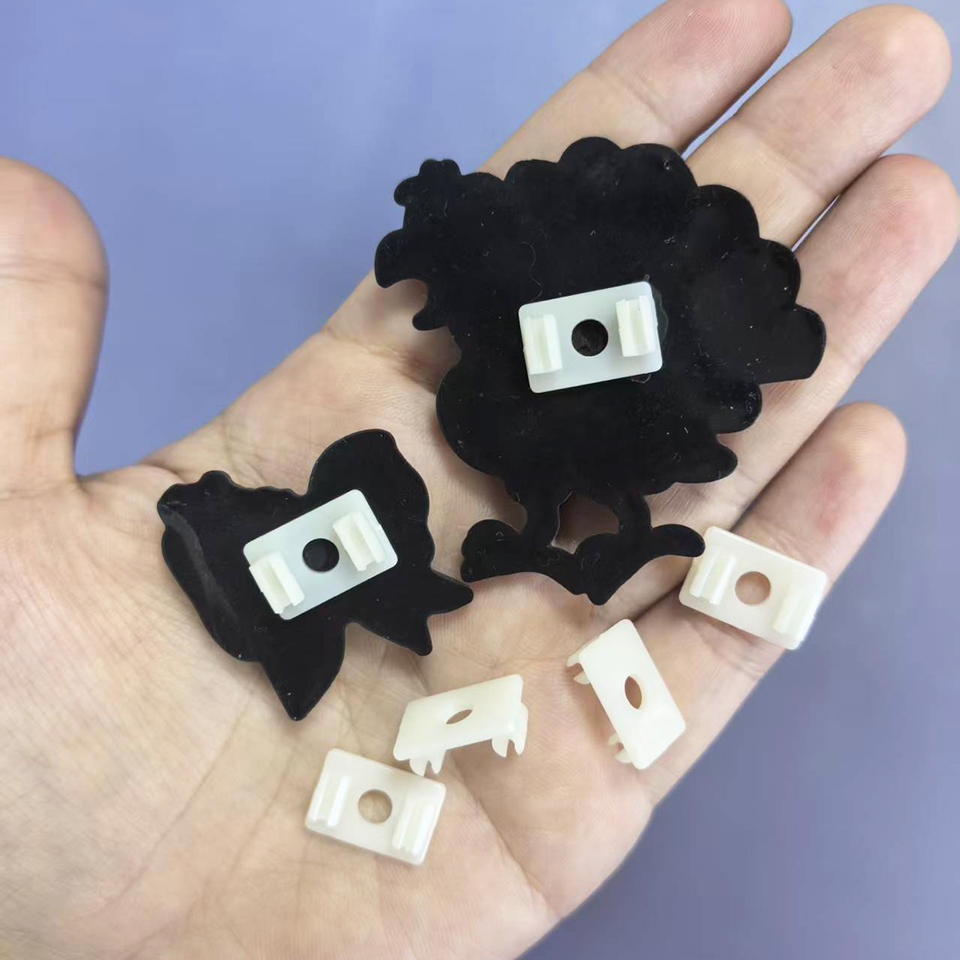 White pen clip charms held in a hand