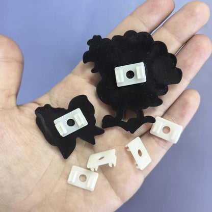 White pen clip charms held in a hand