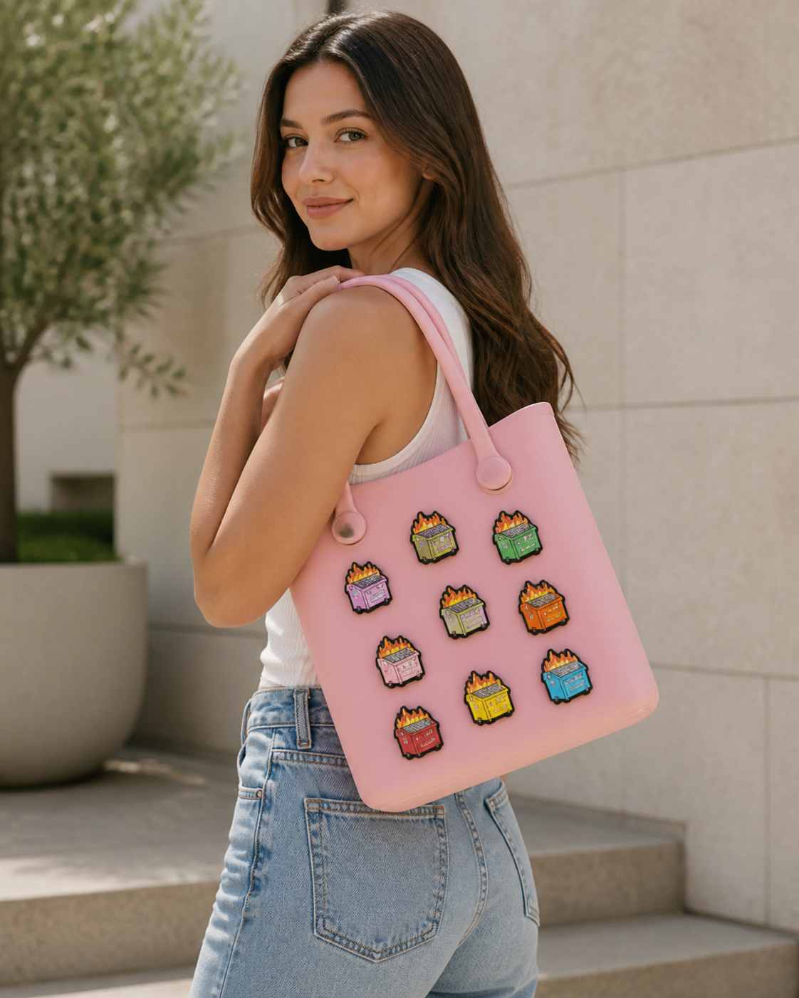 Lifestyle image for custom rubber bag charms carried on a soft pink tote bag